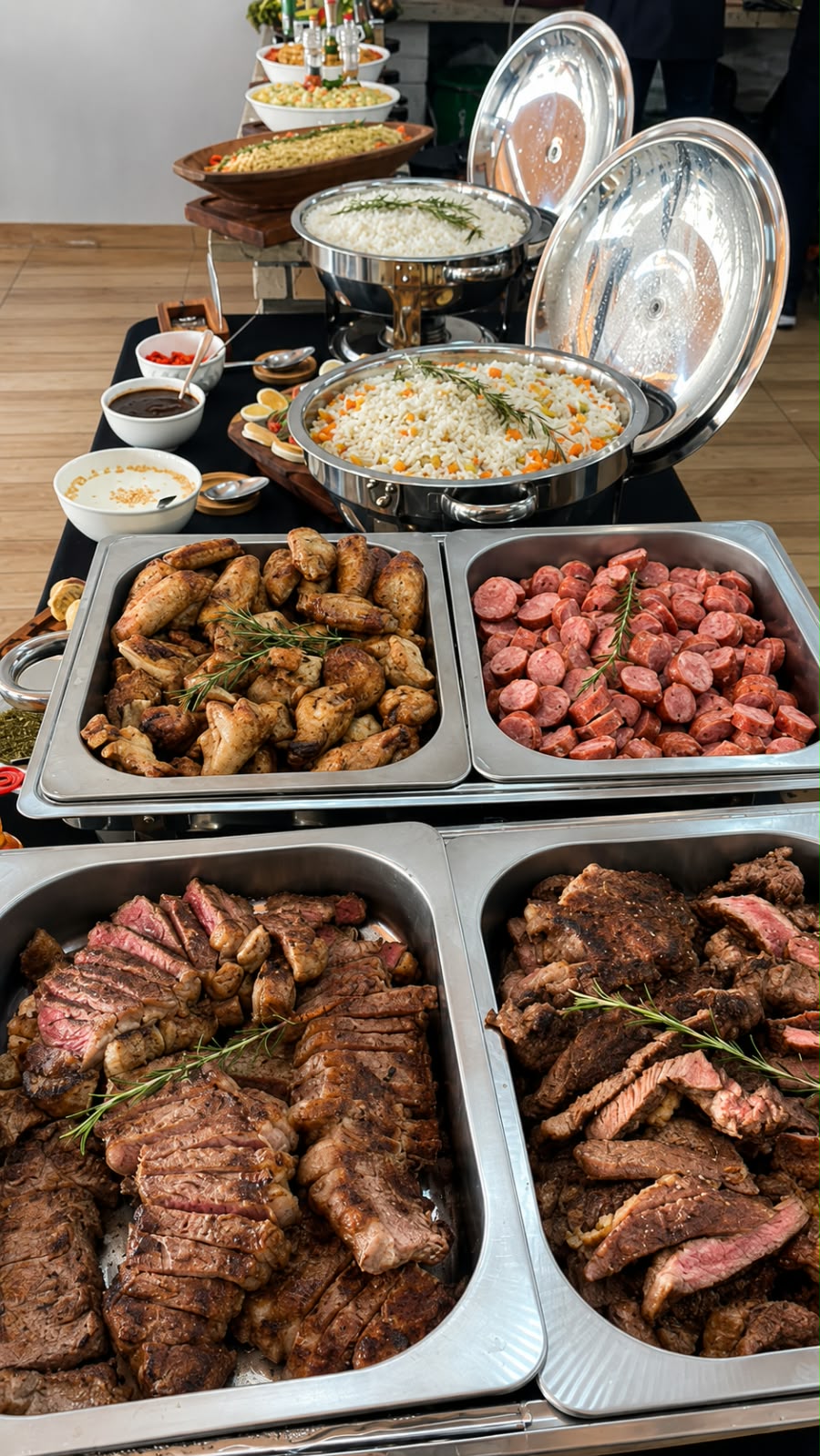 Buffet com carnes fatiadas, frango, linguiça, arroz e acompanhamentos